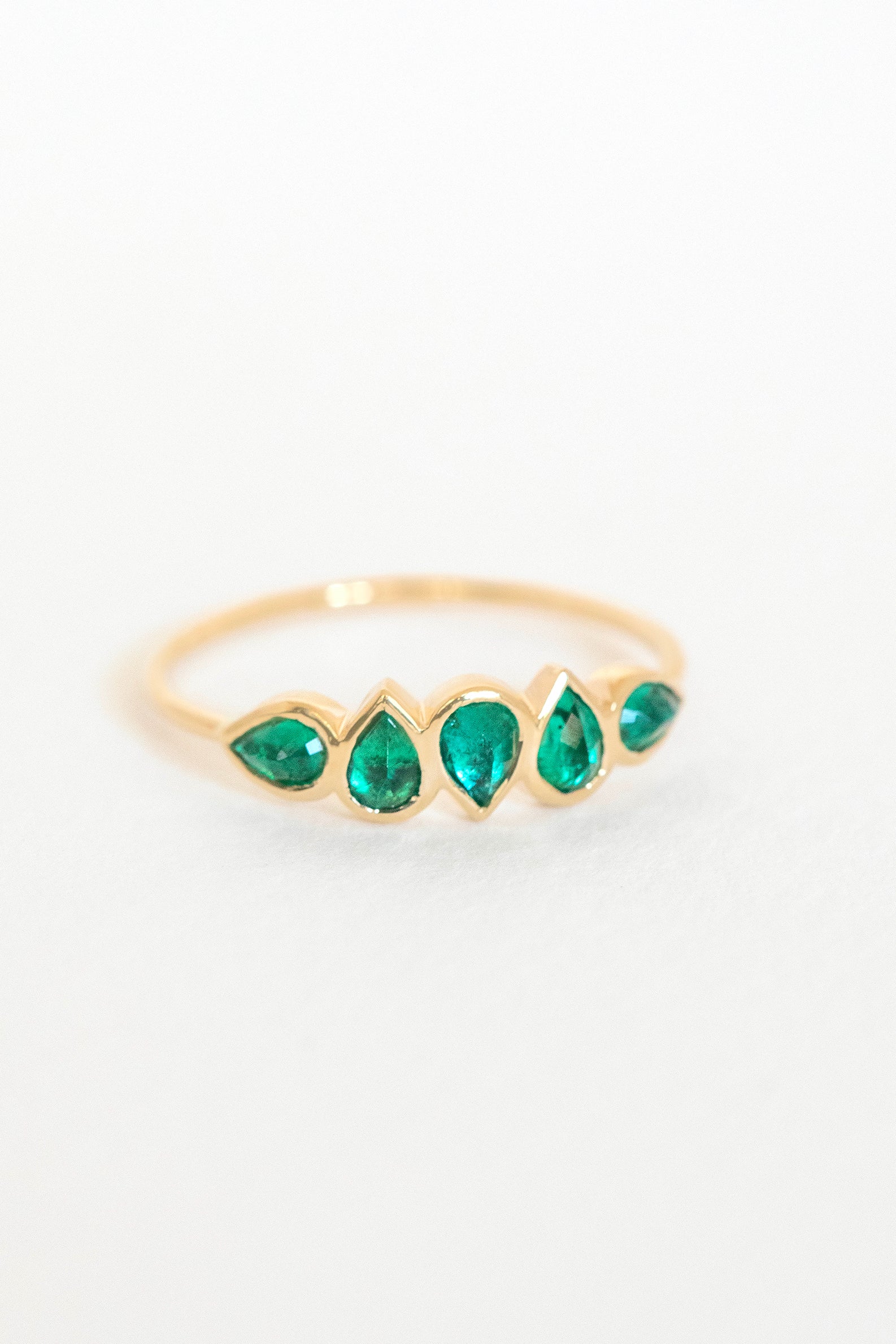 Multi emerald ring in 14k yellow gold with five pear-shaped emeralds by Celine Daoust."