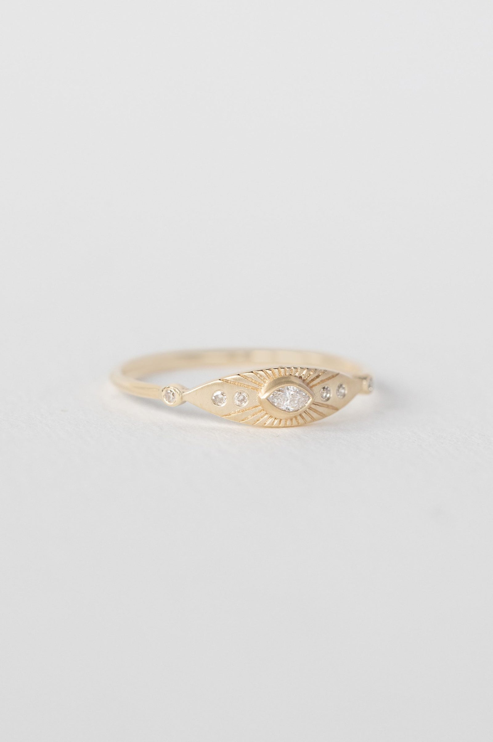 Sun eye ring in 14k yellow gold with a marquise diamond and six accent diamonds by Celine Daoust.