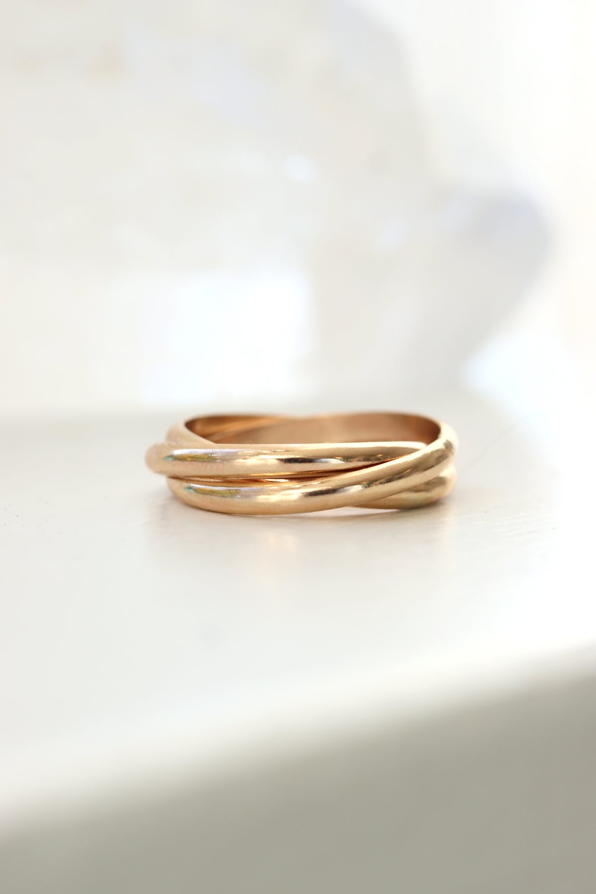 Align rolling ring with three gold bands in an interlocking design