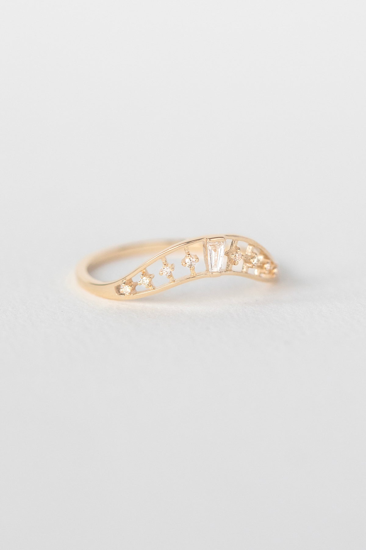 Crown ring in 14k light yellow gold set with a baguette diamond by Celine Daoust.