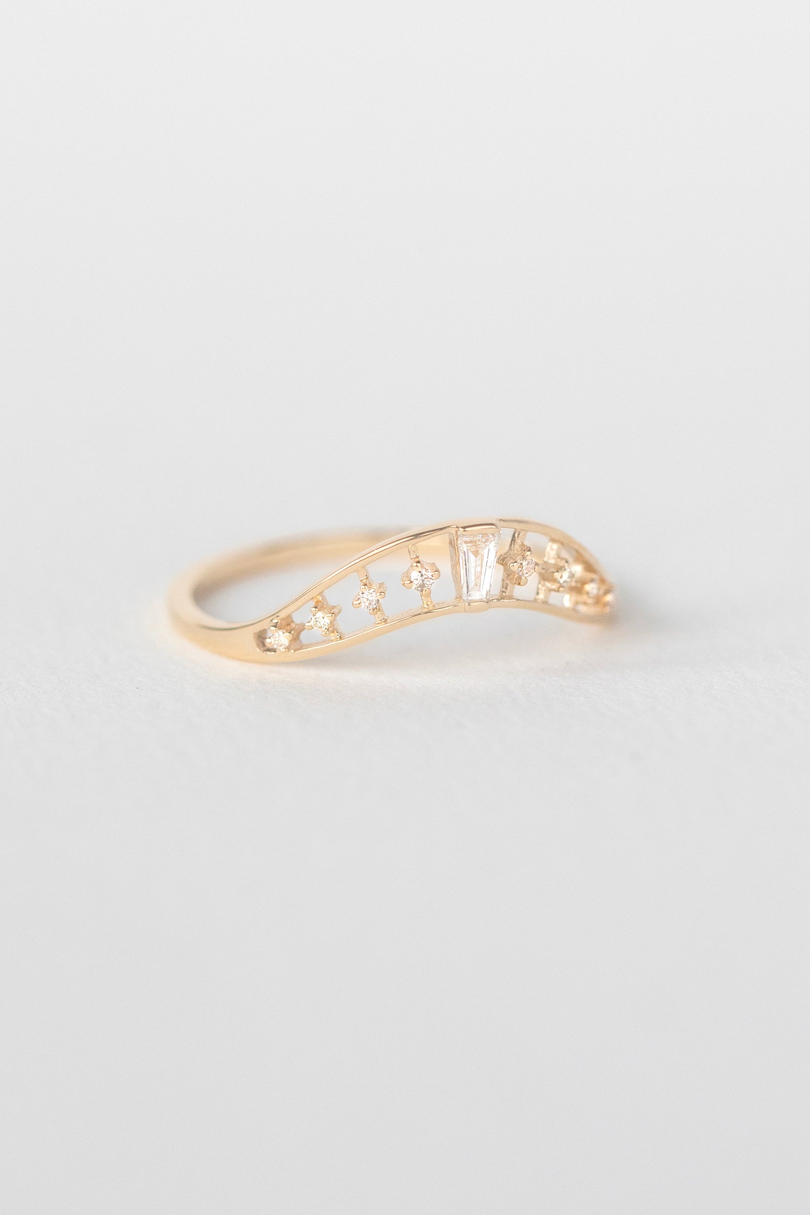 Crown ring in 14k light yellow gold set with a baguette diamond by Celine Daoust.