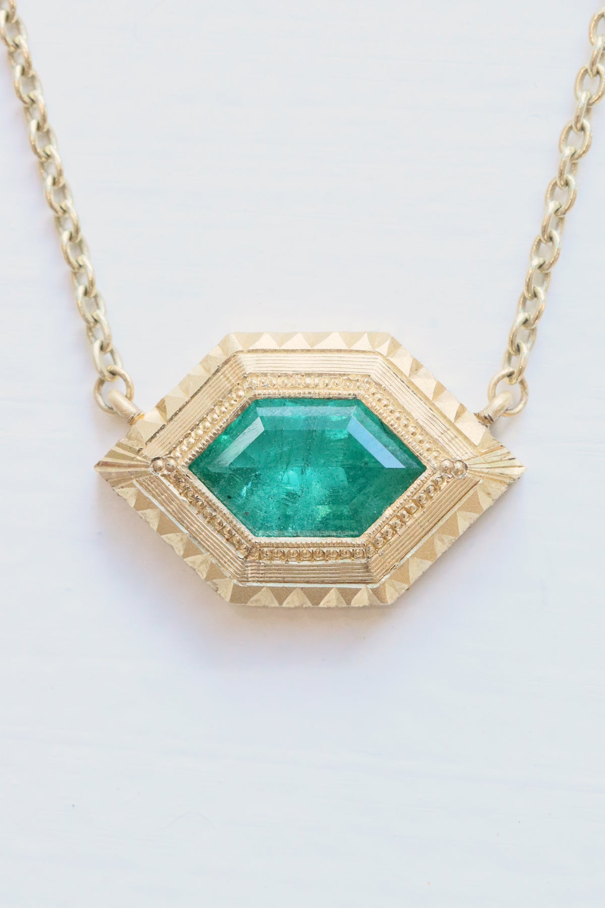 Aria emerald necklace in 18k gold with hand-engraved milgrain detailing by Erin Cuff.