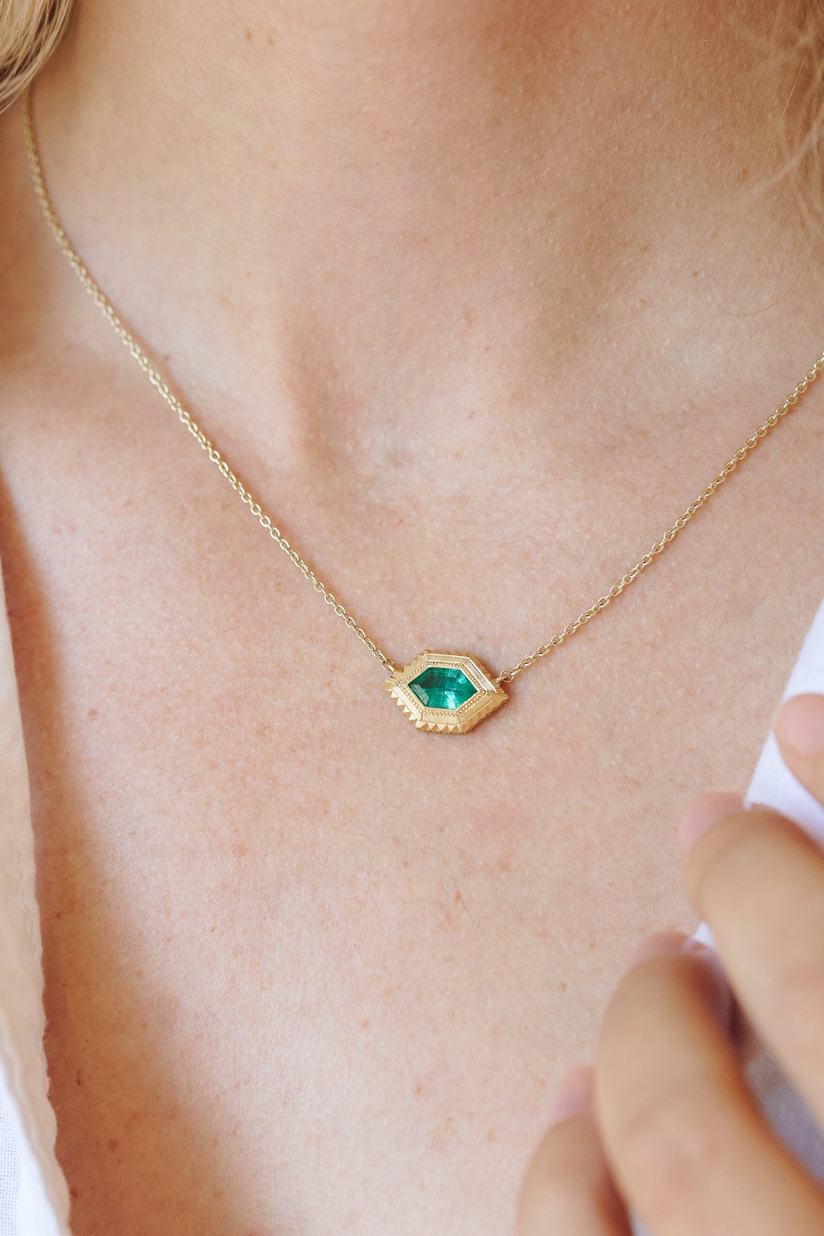 Aria emerald necklace in 18k gold with hand-engraved milgrain detailing by Erin Cuff.