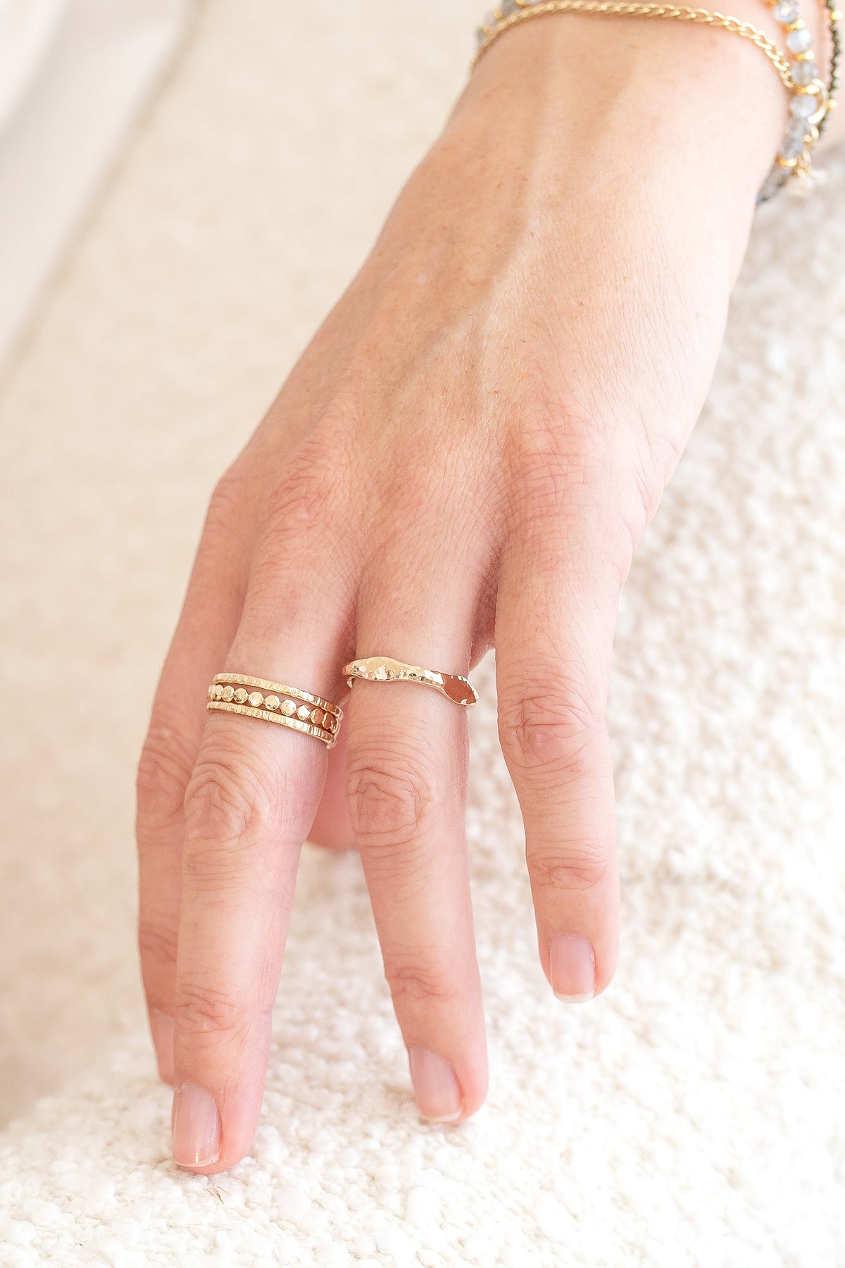 Hand wearing a gold fill wave ring featuring a gently hammered, organic band.