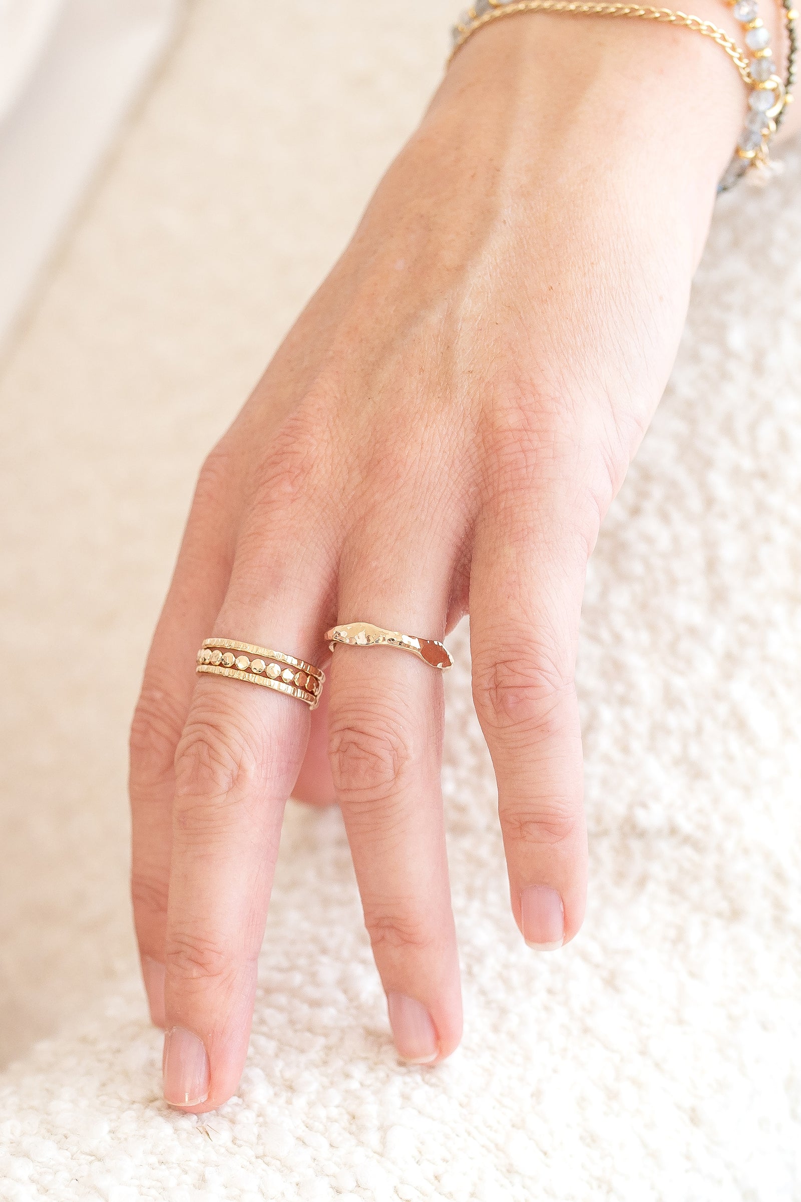 Hand wearing a gold fill wave ring featuring a gently hammered, organic band.