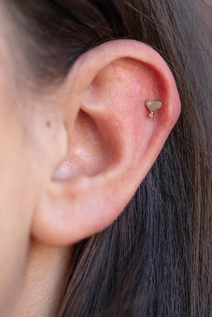 Diamond heart stud flatback piercing in 14k light yellow gold by Celine Daoust.