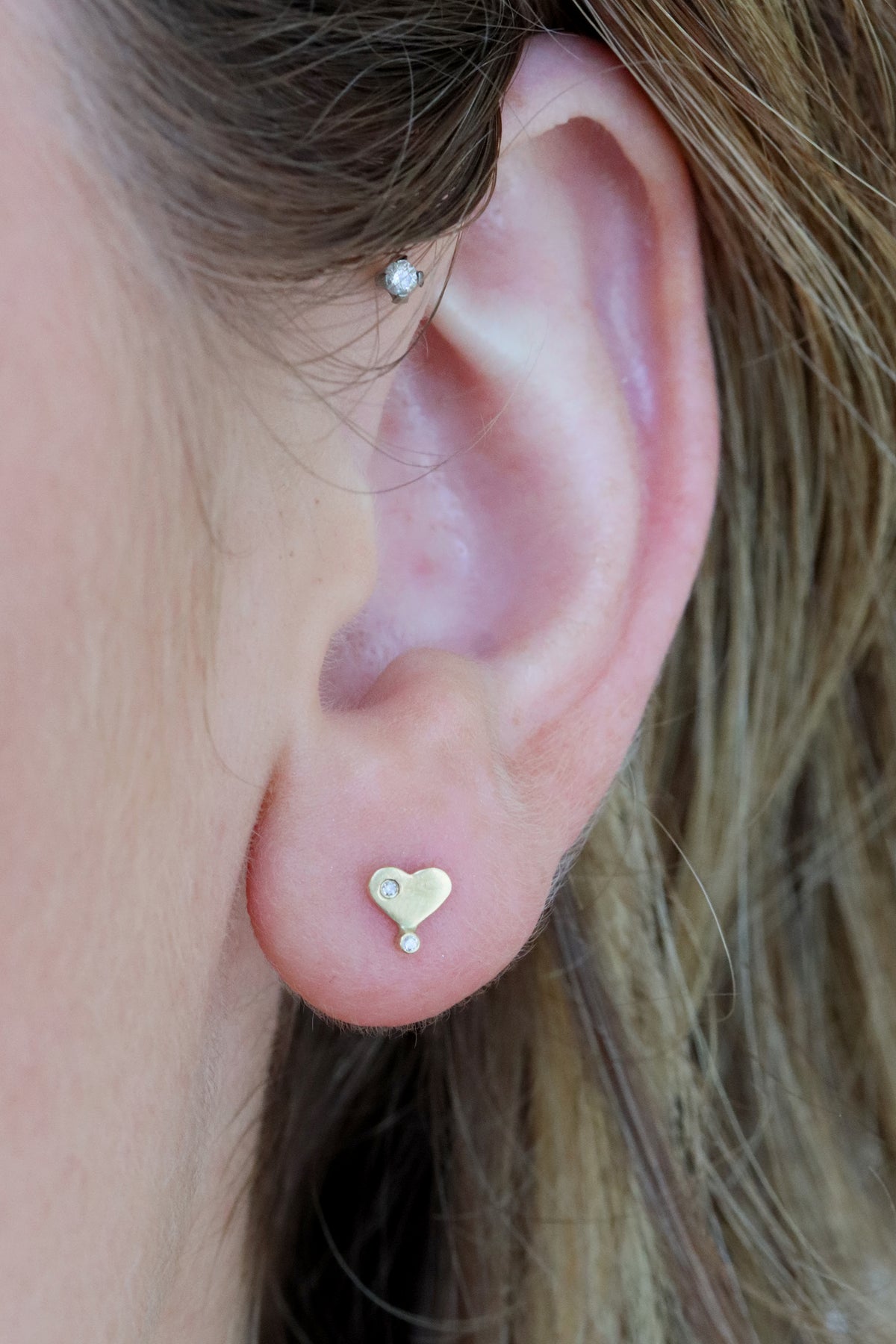 Diamond heart stud flatback piercing in 14k light yellow gold by Celine Daoust.