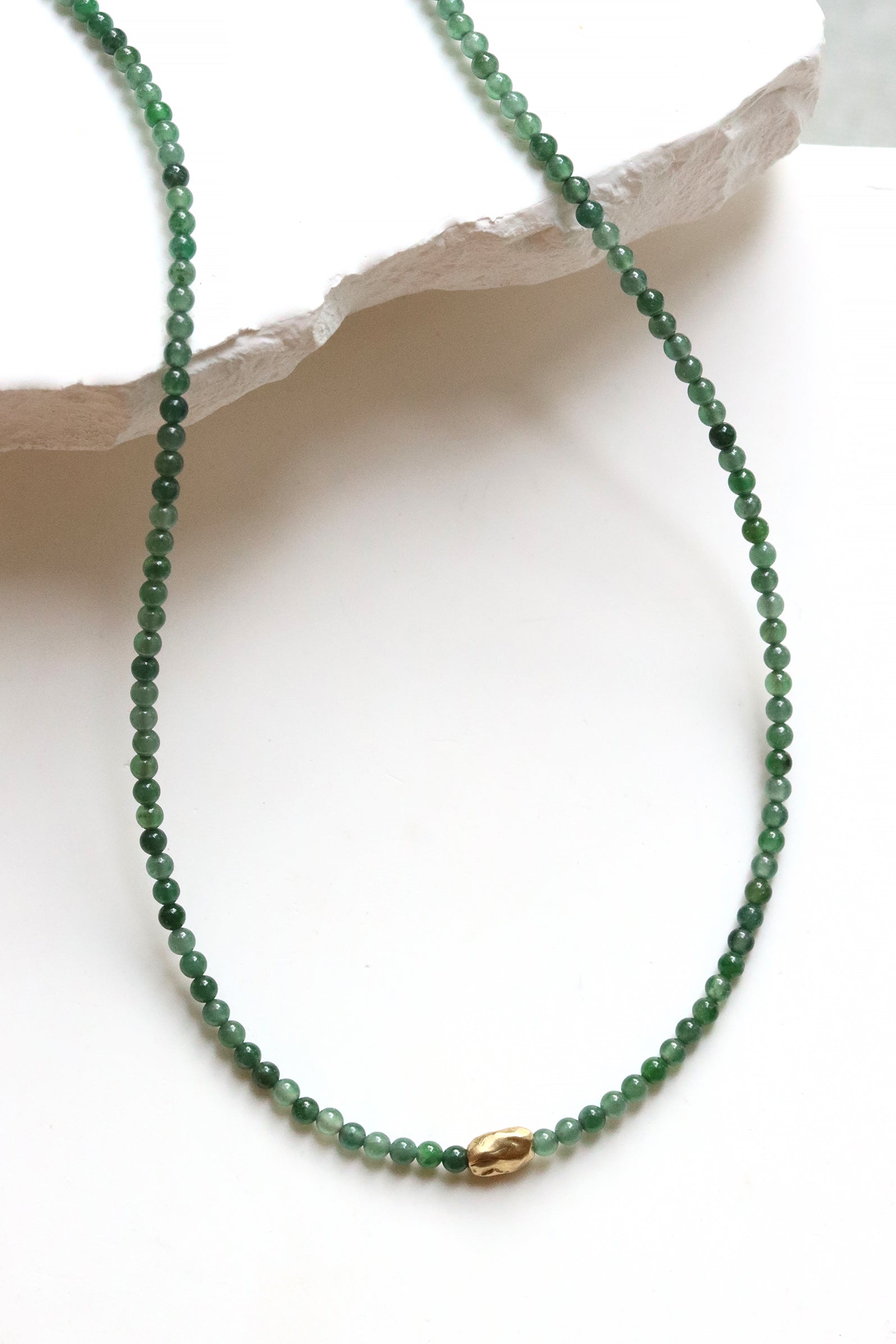 Jade Necklace or wrap bracelet with Guatemalan jade beads and a gold accent bead, white background