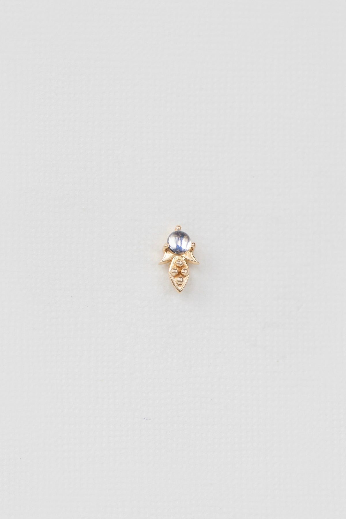 Close-up of rainbow moonstone single stud earring in 14k gold.