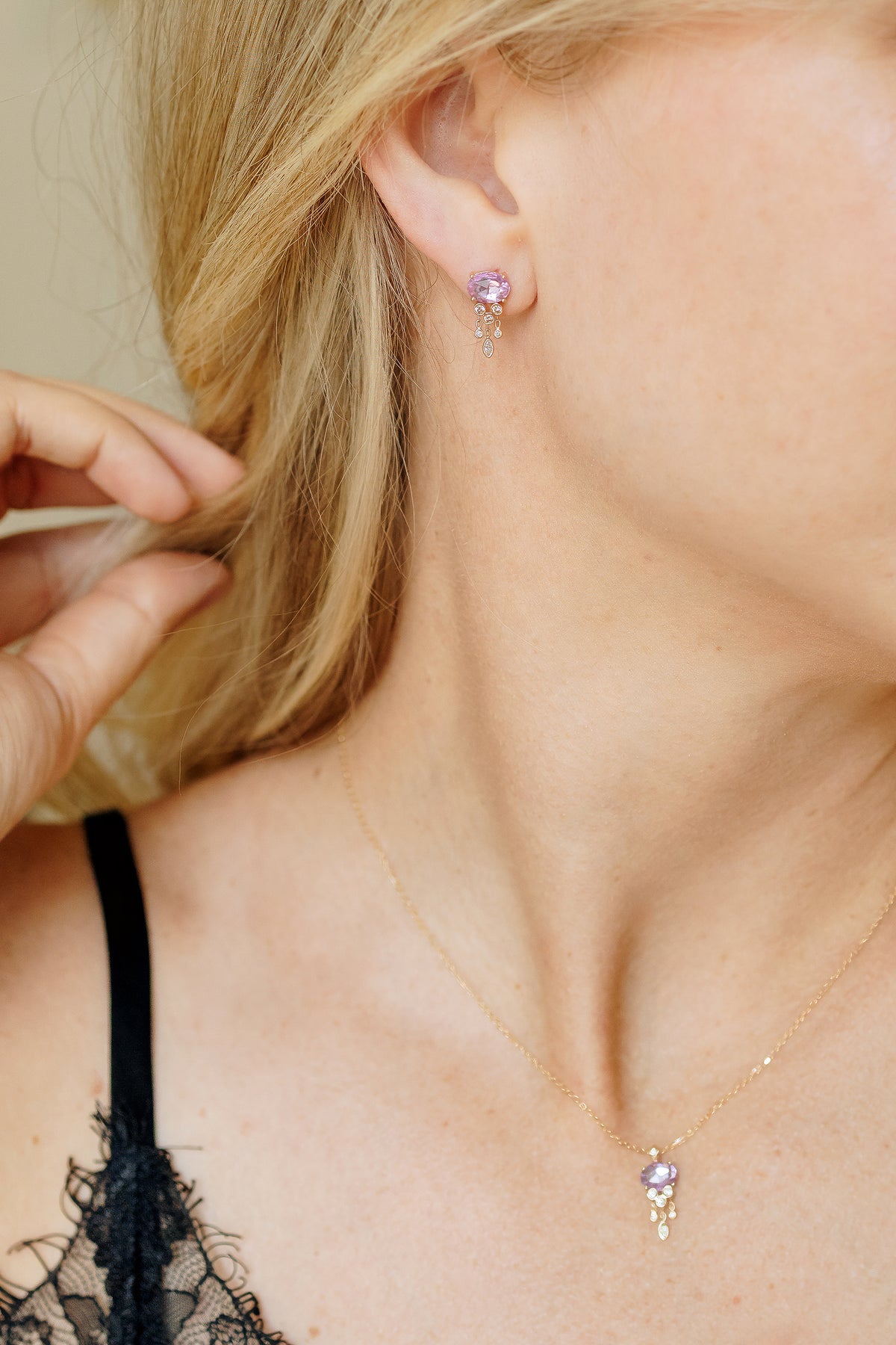 Woman wearing pink sapphire and diamond jellyfish stud earrings in 14k yellow gold by Celine Daoust.
