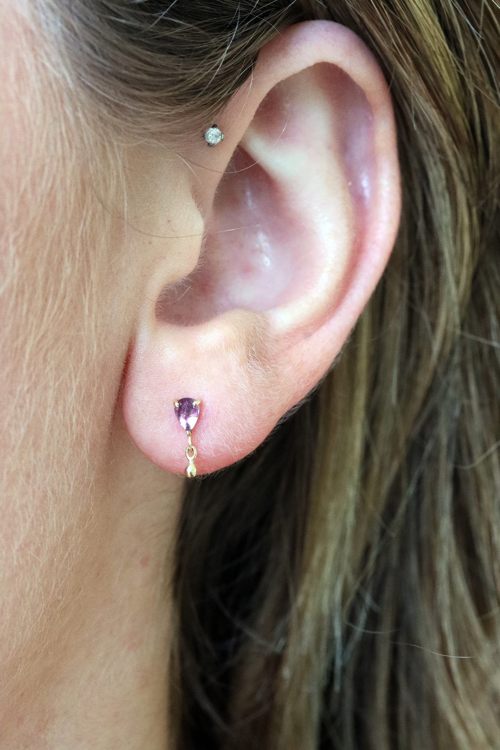 Close-up of the pear pink tourmaline and dangling gold detail on the flatback earring by Celine Daoust