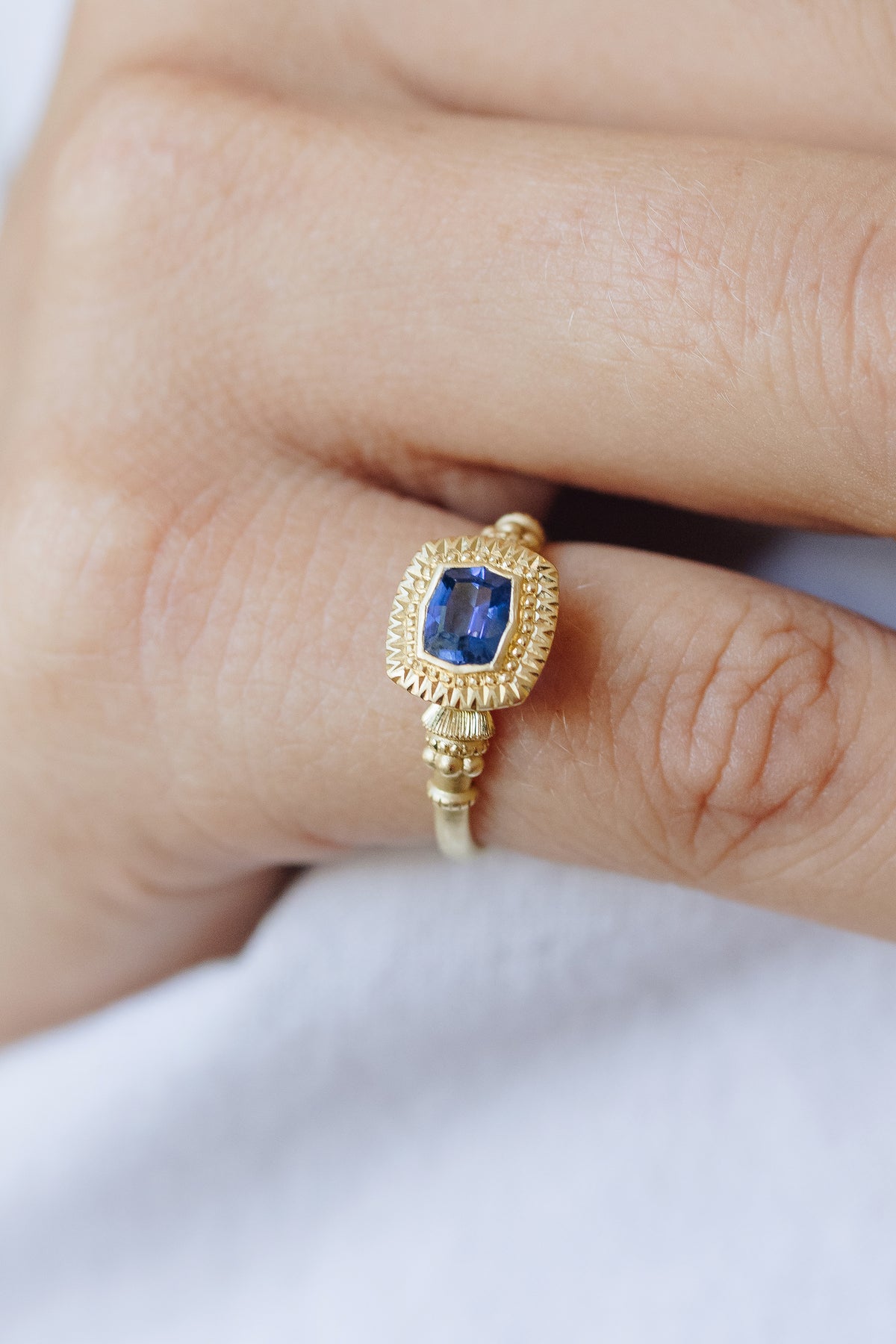 Victoria pedestal solitaire ring in 18k gold with a natural Ceylon sapphire by Erin Cuff.