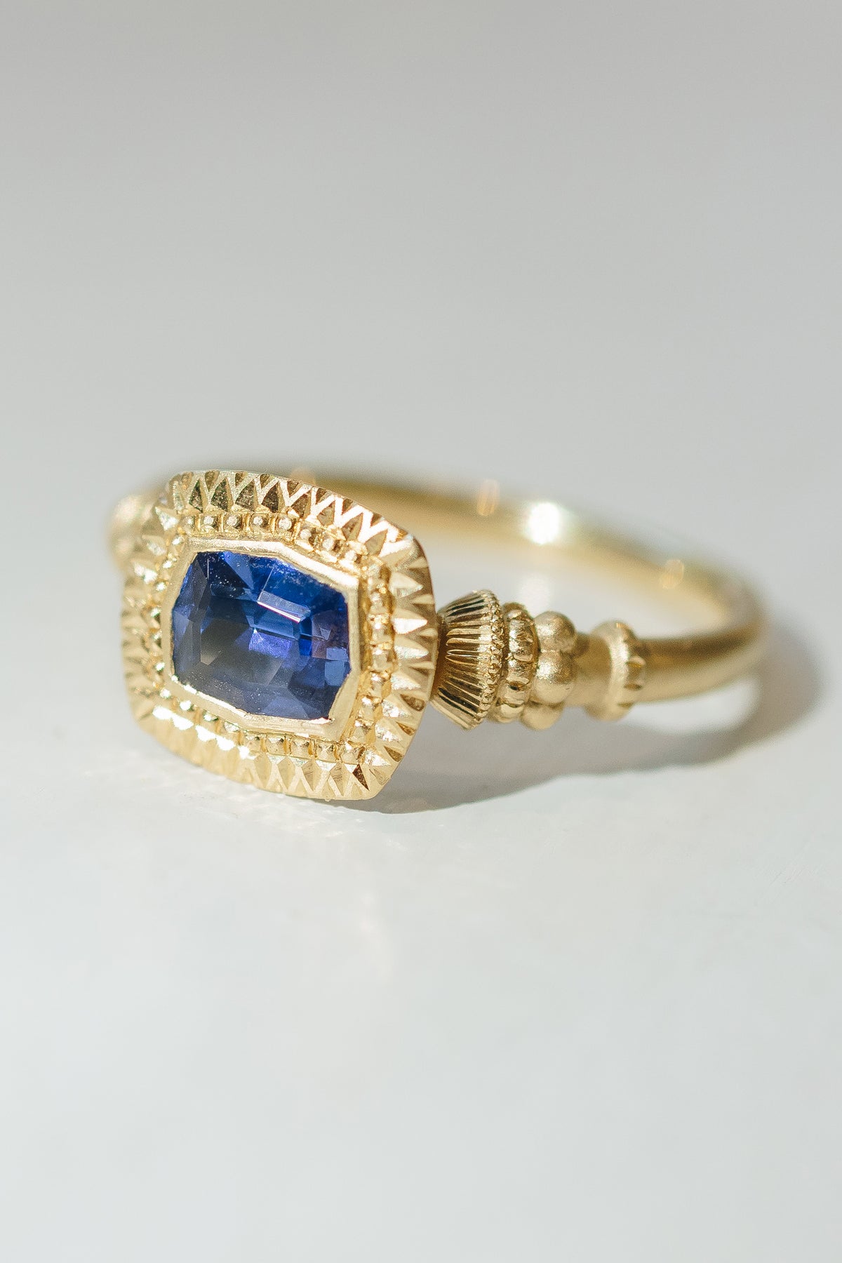 Victoria pedestal solitaire ring in 18k gold with a natural Ceylon sapphire by Erin Cuff.