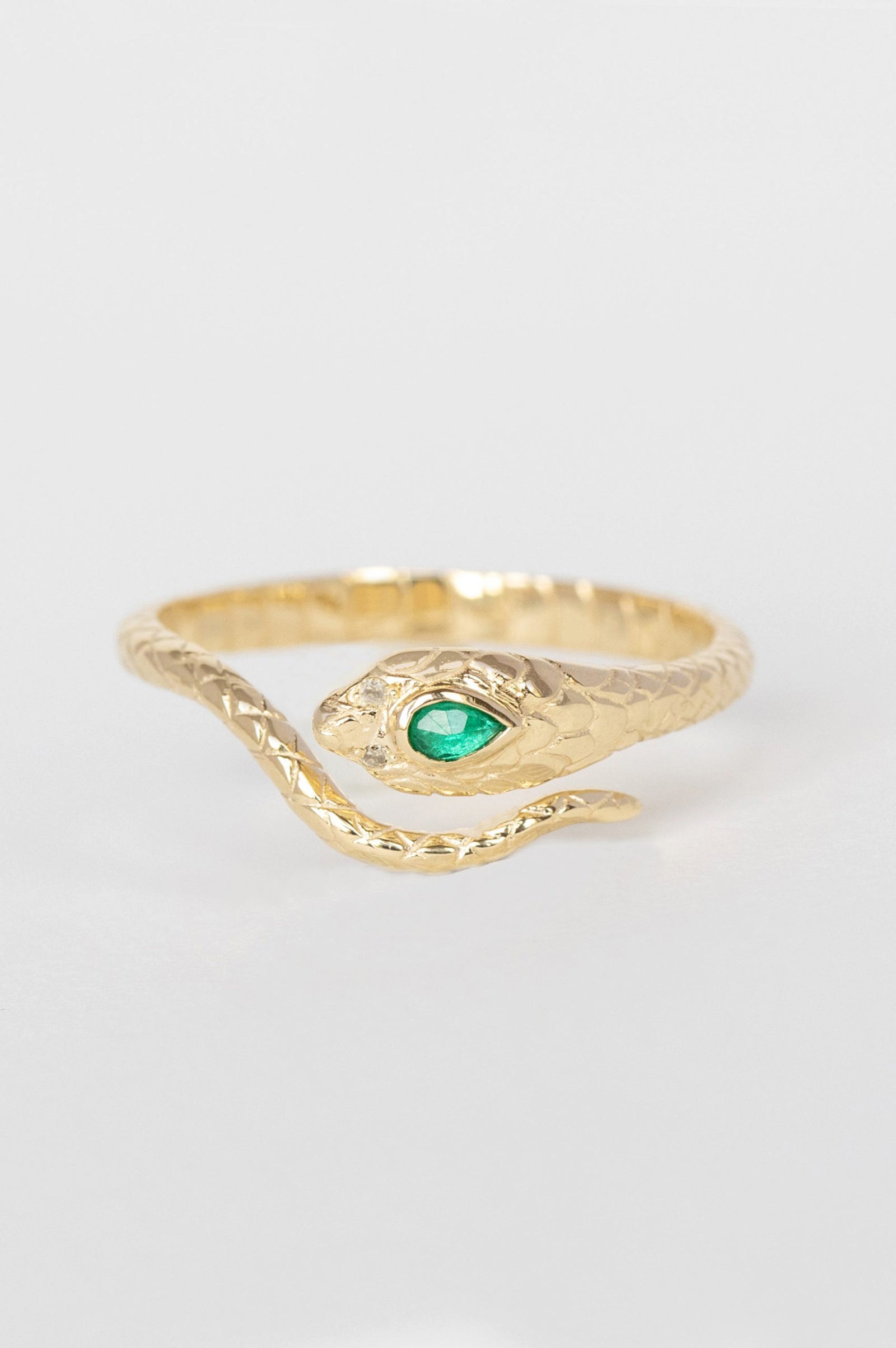 Cobra ring in 14k yellow gold set with an emerald and two diamonds by Celine Daoust.