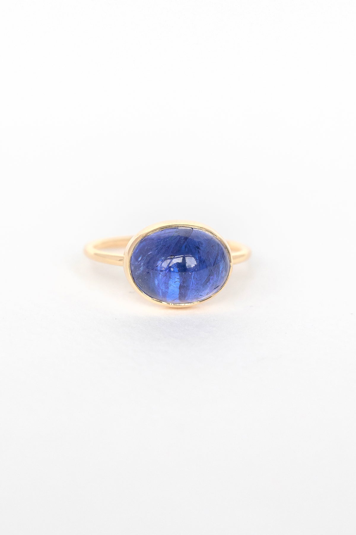 Close-up of blue cabochon tanzanite stone set in 14k yellow gold on the Faye ring by Celine Daoust
