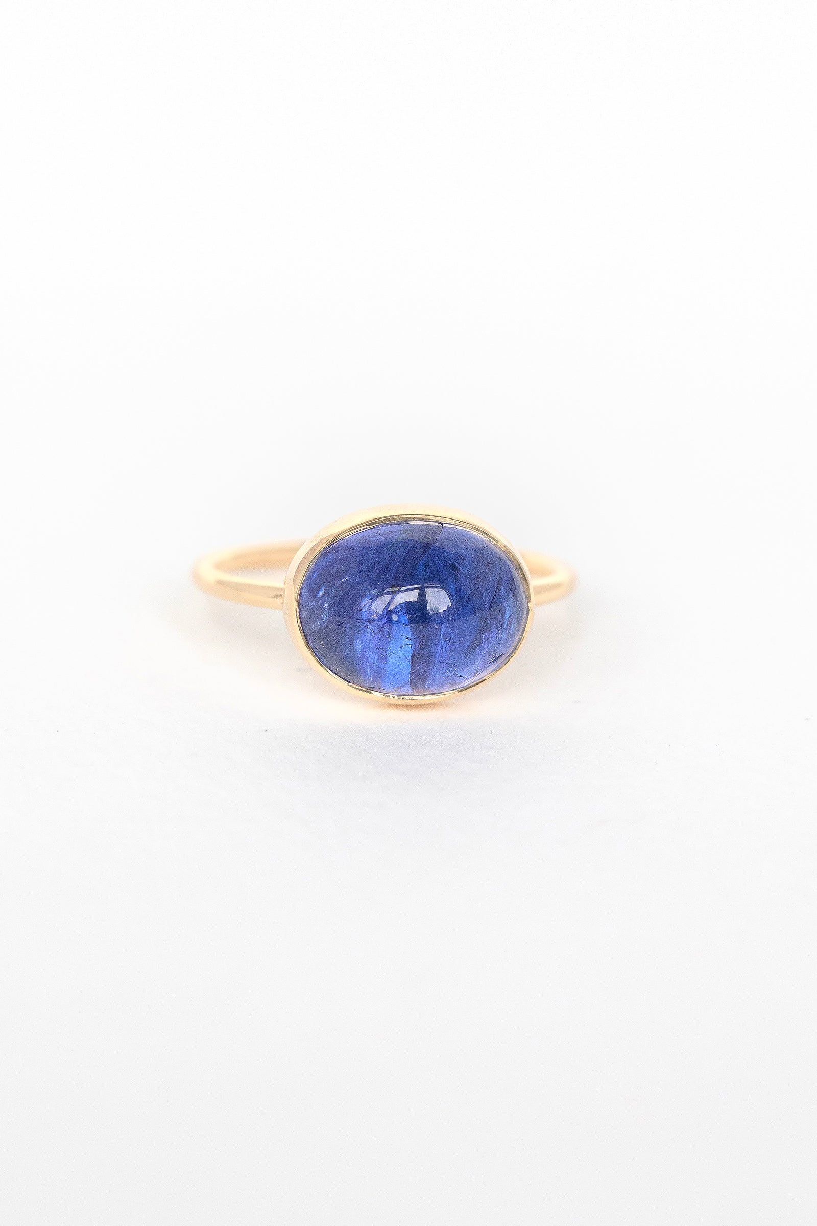 Close-up of blue cabochon tanzanite stone set in 14k yellow gold on the Faye ring by Celine Daoust