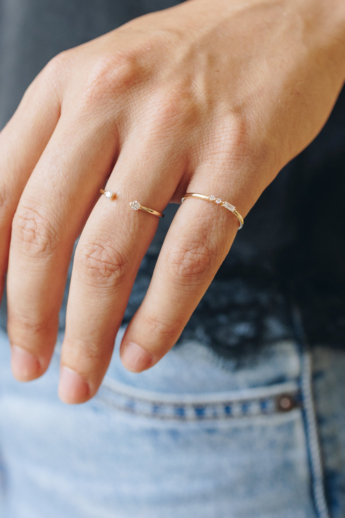Baguette lab diamond beside two round lab diamonds, set off-center on a 14K yellow gold band
