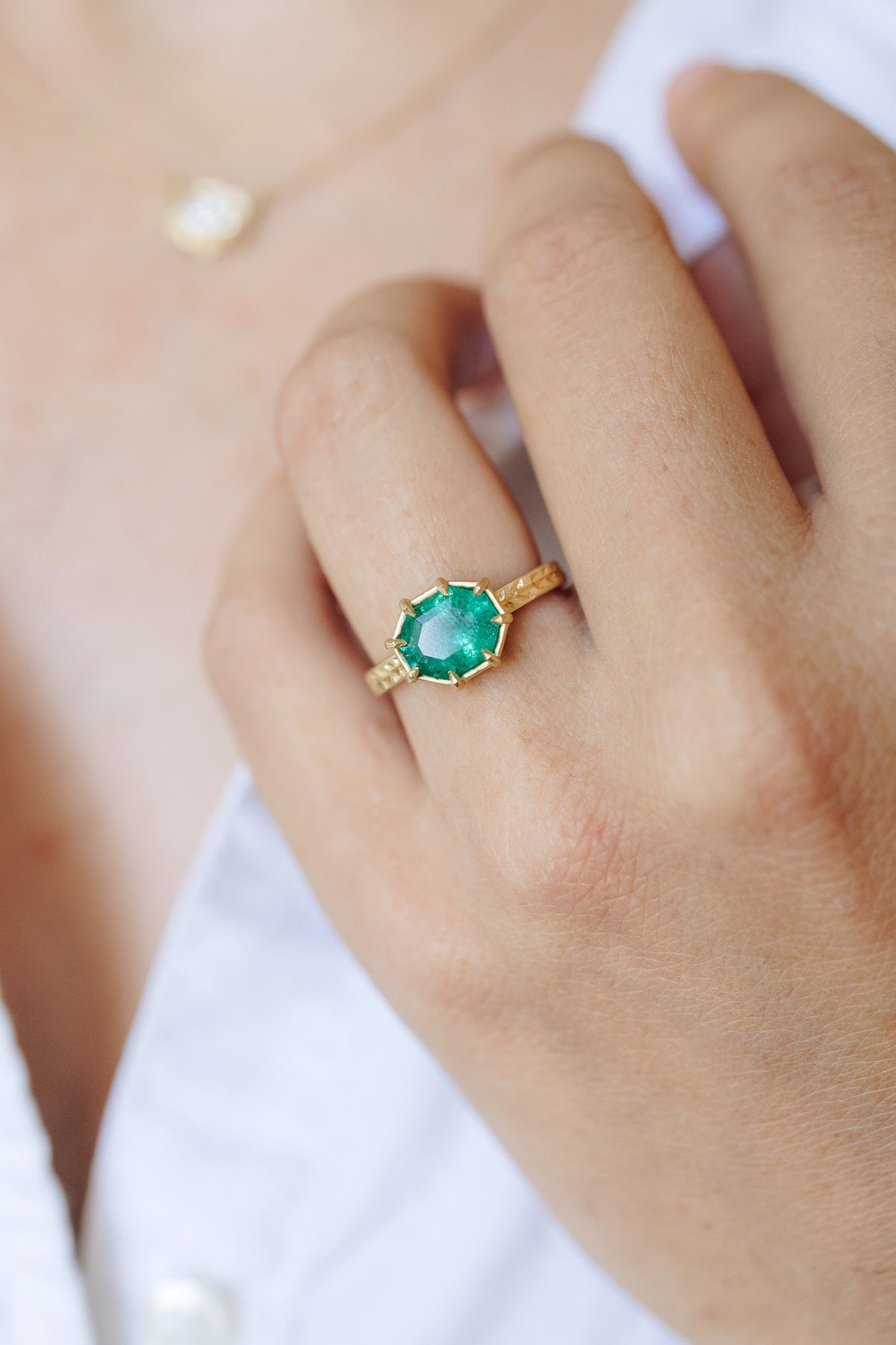 Willow Basket emerald solitaire ring in 18k gold with hand-engraved willow leaves by Erin Cuff.